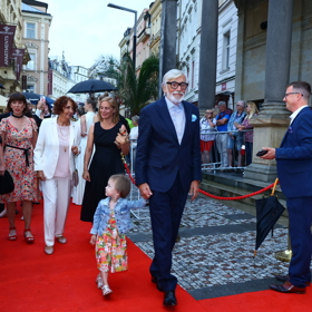 Prezident karlovarského filmového festivalu Jiří Bartoška pyšně přivádí na červený koberec svoji téměř tříletou vnučku Andulku. 