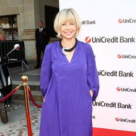 Herečka Jana Švandová ve fialových šatech na karlovarském večírku. Kombinuje fialovou s oranžovými sřevíčky.