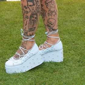 Bílé boty raperky Sharloty jsou na vysoké platformě.