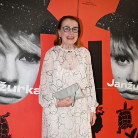 Iva Janžurová vynesla na premiéru dokumentu o své osobě průhledné světlé šaty s potiskem kruhů, které doplnila šedivým psaníčkem a šedivými lodičkami na nízkém podpatku.