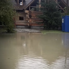 Hrubá stavba srubu je obklopena vodou. 