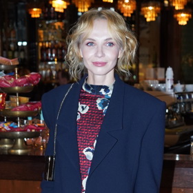 Jana Plodková kombinuje tmavě modré sáčko a hnědé šaty s potiskem.