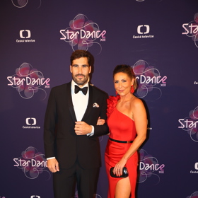 Bývalý účastník StarDance, olympijský vítěz David Svoboda, s doprovodem. Dáma oblékla oblékla rudé večerní šaty s nebezpečně vysokým rozparkem.