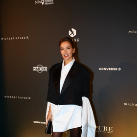 V modelu Michaela Kováčika se v publiku objevila také modelka Andrea Bezděková. Ta vynesla nadměrnou bílou košili s prodlouženými rukávy a zkrácené smokingové sako. Outfit doladila krásnými saténovými střevíčky na platformě s trendy prvkem - páskem kolem kotníku.