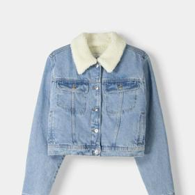 Tradiční a stylová. Džínová bunda typu trucker s límcem a podšívkou z umělé kožešiny. Bershka, 999 Kč.
