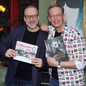 Hostitel Aleš Cibulka se svým partnerem Michalem Jagelkou. Cibulka oblékl veselou košili plnou psacích strojů, jeho partner elegantní tmavě modré sáčko.