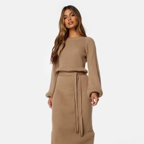 Zavinovací silueta sluší ženám napříč věkovým kategoriím a typy postavy. Je totiž vhodná i pro plnější tvary. V midi délce se skvěle kombinuje s volnějšími kozačkami, které dámy plus size velikostí obvykle ocení. Šaty z žebrovaného úpletu, Bubbleroom, 1 459 Kč