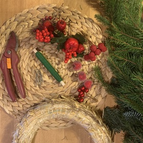 Na adventní věnec k zavěšení na dveře budete potřebovat větve chvojí různých jehličnanů (můžete použít jeden druh nebo jich využít i více najednou). Dále si připravte slaměnný korpus, špulku zeleného vázacího drátku, zahradnické nůžky, aranžérské sponky a ozdoby, kterými chcete věnec ozvláštnit.