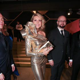 Modelu ve zlatých tónech dominovala  obří aplikace na rameni. Nechyběla zlatá kabelka a zlaté boty.