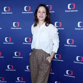 Sympatická brunetka v trendy širokých kalhotách s kostkou, které doplnila o klasickou bílou košili a boty z hnědé broušené kůže.