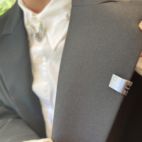 Součástí jeho modelu byla také metalická spona na klopě.