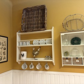 Nad stolem je několik poliček s hrníčky a jinými drobnostmi.