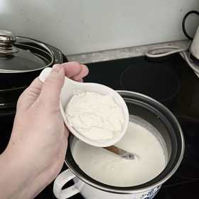 V této fázi do teplého mléka vmícháme 2 lžíce jogurtu. Můžeme si je nejprve stranou smíchat s trochou teplého mléka a potom směs přilít do hrnce, ale není to nutné.