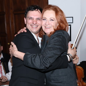 Na oslavu se potom převlékla do tmavě šedého kalhotového kostýmku s proužky.