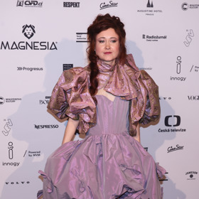 Režisérka Eva Toulová vynesla objemnou nabíranou róbu s balonovými rukávy v metalických odstínech fialové. Doplnila ji uzavřenými střevíčky v tělové barvě.