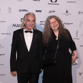 Oldřich Kaiser v klasickém pánském obleku a v doprovodu partnerky Dáši Vokaté. Ta oblékla elegantní černé šaty s tříčtvrtečním rukávem. Vlasy nechala - jako vždy - rozpuštěné. 