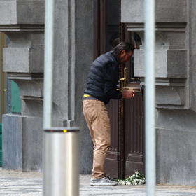 Lidé nosí květiny a svíčky před dům Jiřího Bartošky.