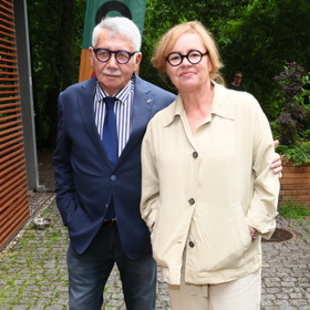 Jitka Sedláčková oblékla béžový komplet bundičky s knoflíky a širokých kalhot doplněných o zelené tenisky. Její partner Pavel Töpfer byl opět za elegána v saku, kravatě a košili, ale pro tentokrát oblékl džíny. 