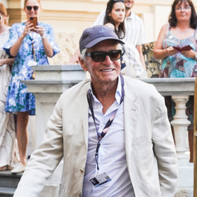 Oblečený v bílé košili, krémovém saku a kšiltovce pozdravil fanoušky před hotelem Pupp.