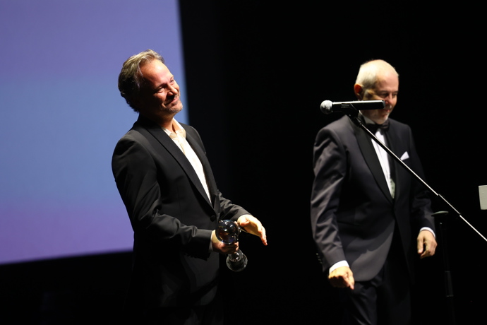 FOTO: Peter Sarsgaard na pódiu. – stránka 11