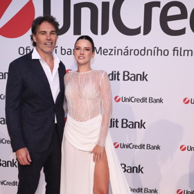 Hokejista Jaromír Jágr svou partnerku, modelku Dominiku Branišovou, doplnil ležérně pojatým tmavým oblekem, který doplnil bílou košilí s rozhalenkou a bílými teniskami.