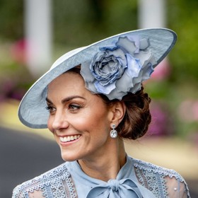 Další ikonický look Kate. Na dostihy v Ascotu roku 2019 si nechala zaplést složitý drdol po straně tak, aby korespondoval s úhlem fascinátoru.