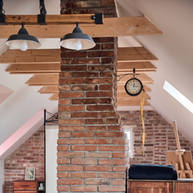 Cihlový komín, který vede od krbu ve spodní místnosti, v prostoru ničemu nevadí a krásně sem zapadá.