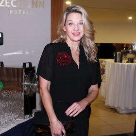 Herečka a moderátorka Sabina Laurinová oživila černý outfit červenou květinovou broží.