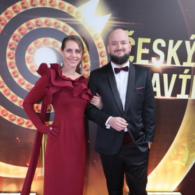 Eliška se zahalila do opulentní vínové róby s asymetrickým rukávem. 