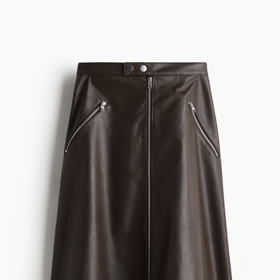 Áčková koženková sukně se zipy dodala oufitu Evy Burešové eleganci i rebelský nádech. Tuto má v nabídce H&M, za 739 Kč.