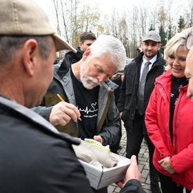 Petr Pavel se podepisuje na hliněnou nádobu.