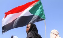 Studenti drží súdánskou vlajku během protestu proti porušování lidských práv spáchaného Jednotkami rychlé podpory (RSF).