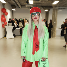 Sharlota vynesla kontrastní kombinaci neonově zelené košile, rudých kalhot, kravaty a baretu. Vše doplnila originální neonovou kabelkou. 