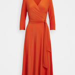 Šaty s výstřihem do V a zavinováním jsou nesmírně lichotivé. Tento výrazný oranžový model je od značky Lauren Ralph Lauren a stojí 5200 Kč.