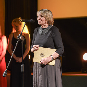 Eliška Balzerová oblékla šedý komplet skládané sukně a topu s ozdobným límečkem.