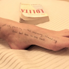 Žena má na noze napsaný citát z knihy Lolita.