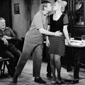 Snímek ze seriálu Chalupáři z roku 1975. Na foto Jaroslav Moučka, Václav Sloup a Gabriela Vránová při trénování divadelní scény v epizodě s názvem Režisér.