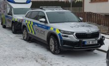 Policisté a hasiči před domem v Třešti, kde se stala vražda.