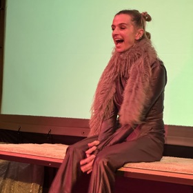 Oblékla speciálně navržený tmavě hnědý dres na bikram jógu a chlupaté boa, které sehnala na Temu. 