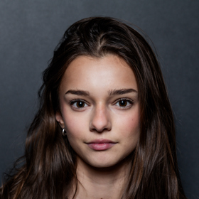 Mladá slečna má dlouhé kaštanově hnědé vlasy. 