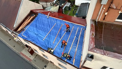 FOTO: Provizorní zajištění poškozené střechy pomocí plachty, aby do obytných prostor dál nezatékalo.