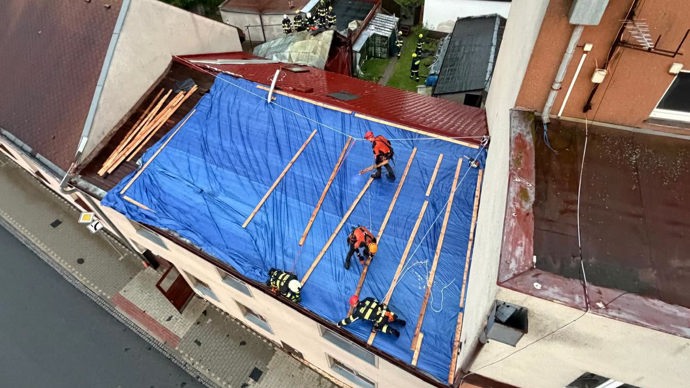 FOTO: Provizorní zajištění poškozené střechy pomocí plachty, aby do obytných prostor dál nezatékalo. – stránka 1