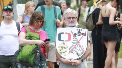 FOTO: Účastník protestu drží štít s grafikou varující před tím, aby politici utáhli České televizi finanční kohoutky.