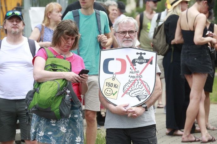 FOTO: Účastník protestu drží štít s grafikou varující před tím, aby politici utáhli České televizi finanční kohoutky. – stránka 14