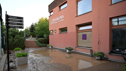 FOTO: Voda se zastavila až těsně u oken hlavní budovy Pliskova Tennis Academy, kde vytvořila obří kaluže.