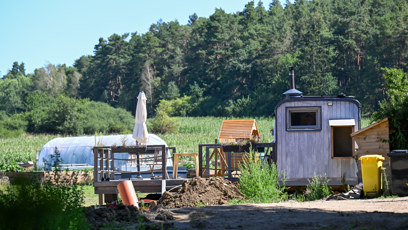 FOTO: Zahrádka a maringotka, ve které rodina trávila první měsíce.