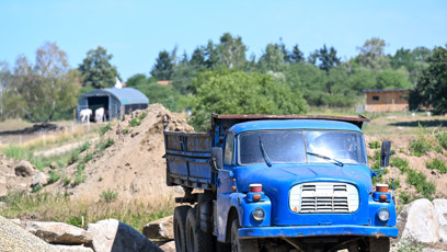 FOTO: Modrý sklápěč pomáhá s navážením materiálu a terénními úpravami.