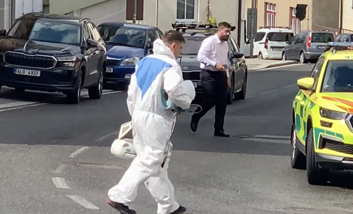 FOTO: Kriminalistický technik v ochranném obleku vynáší z domu kufry s důkazy. – stránka 6