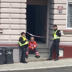 Záchranář sedící na schodech bytového domu byl po zásahu viditelně otřesený.