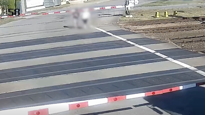 FOTO: Dva muži se vydali přes železniční přejezd, i když byly dole závory a blikala červená světla.